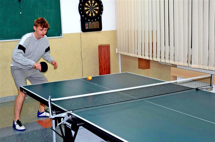 Turniej tenisa stołowego - jeden z uczestników przy stole tenisowym podczas gry