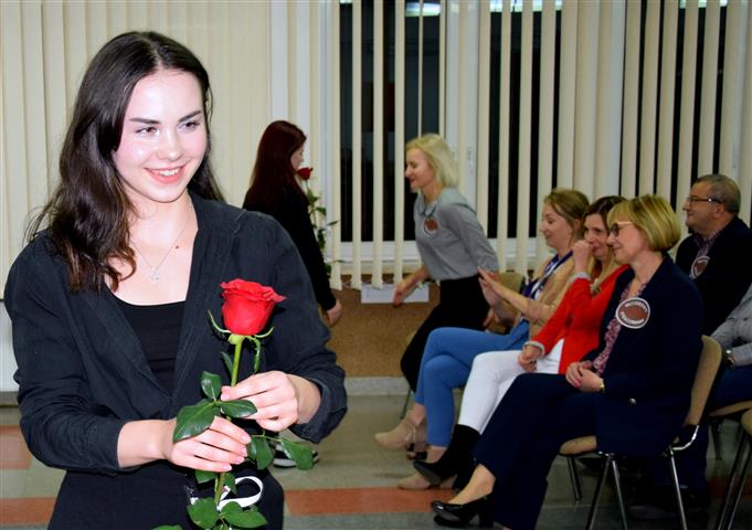 Wychowankowie wręczają czerwone róże pracownikom bursy