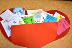 Wielkie, czerwone, papierowe serce wypełnmione kartami z życzeniami