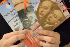 Wychowanka trzyma w dłoniach zakładki do książek pt. Patron roku 2025  na Mazowszu – Antoni Słonimski.