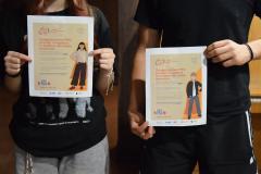 Dwoje wychowanków trzyma plakaty pt. „Osiągnij poziom PRO, prosząc o wsparcie w trudnym dla Ciebie momencie. 