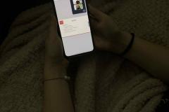 Wychowanka trzyma w ręku telefon komórkowy podczas oglądania webinaru on-line pt. „Zaufane spotkanie. Kryzys – jak go rozpoznać i gdzie szukać wsparcia?”