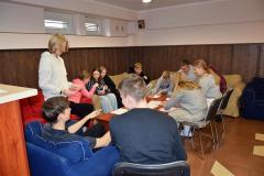 Grupa wychowanków bursy podczas zajęć – młodzież siedzi w kręgu, rozmawia i pracuje  w grupach