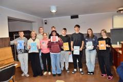 Grupa wychowanków prezentuje plakaty z kampanii „Dzieciństwo bez przemocy”.