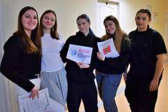 Grupa wychowanek podczas akcji informacyjnej w bursie. Dziewczęta prezentują materiały edukacyjne.