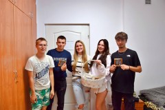 Uśmiechnięci wychowankowie bursy pozują z koszem prezentowym zawierającym czekoladki, którymi obdarowani zostali chłopcy.