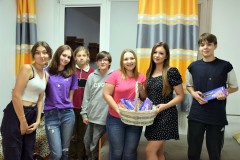 Wychowanki pozują z koszem pełnym czekolad i młodszymi kolegami.