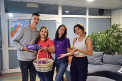 Wychowanki bursy pozują do zdjęcia z kolegą, który prezentuje otrzymaną czekoladę.