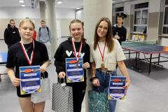 Dziewczęta które zajęły I II i III miejsce w turnieju tenisa stołowego z medalami, dyplomami i nagrodami.