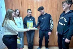 Grupa wychowanków wręcza koledze ulotkę promującą akcję: „Międzynarodowy Dzień Praw Dziecka z UNICEF”.