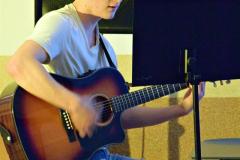 Wychowanek gra na gitarze.