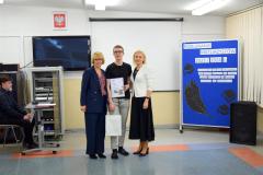 Wychowawca z panią dyrektor i wychowanką, która została nagrodzona pozują do zdjęcia.