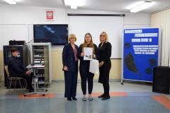 Wychowawca z panią dyrektor i wychowanką, która została nagrodzona pozują do zdjęcia.
