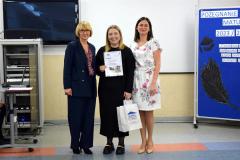 Wychowawca z panią dyrektor i wychowanką, która została nagrodzona pozują do zdjęcia.