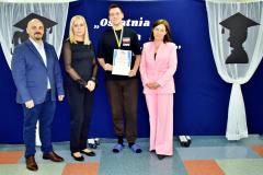 Wychowanek nagrodzony medalem Wzór do naśladowania pozuje do zdjęcia razem z wychowawcami i Panią Dyrektor.