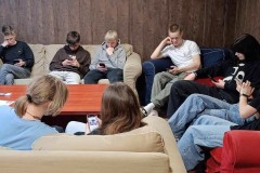 Wychowankowie rozwiązują karty pracy przy użyciu telefonów.