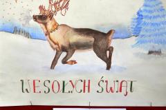 Kartka świąteczna na której znajduje się namalowany renifer, stojący w śniegu. Po bokach stoją niebieskie choinki. Na kartce znajduje się napis: Wesołych Świąt. Pod kartką znajduje się napis: I miejsce: Sieńkowska Luci – Internat przy ZSZ nr 2 w Ostrołęce