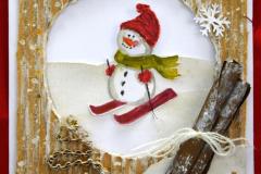 Kartka świąteczna na której znajduje się: w białym okręgu bałwan zjeżdżający na czerwonych nartach. W czerwonej czapce, czerwonych rękawiczkach  i zielonym szaliku. W prawym dolnym rogu znajdują się pałeczki cynamonu owinięte białą włóczką w kokardę. W lewym dolnym rogu znajduje się zrobiona z brązowej tektury choinka. Na górze znajduje się napis: Wesołych świąt. Pod kartką znajduje się napis: III miejsce: Mąka Oliwia – Internat I LO im. gen. Józefa Bema w Ostrołęce