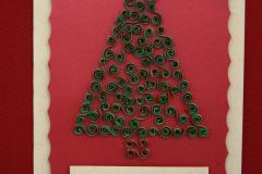 Kartka świąteczna: Na żółtej kartce przyklejona jest czerwona kartka pośrodku której znajduje się zielona choinka z wywiniętych w kółeczka  kartek papieru. Na górze choinki znajduje się żółta gwiazda. Na dole widnie napis: Radosnych świąt Bożego Narodzenia.  Pod kartką znajduje się napis: Wyróżnienie: Gumkowska Małgorzata  – Internat przy ZSZ nr 2 w Ostrołęce