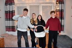 Dwóch chłopców oraz dwie dziewczyny pozują z koszykiem z czekoladkami