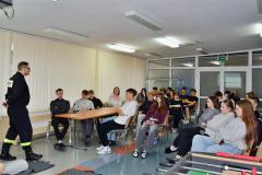 Wychowankowie siedzący na krześle oraz słuchający Strażaka