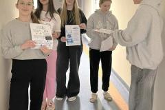 Młodzież z Koła Wolontariatu przeprowadza akcję informacyjną dla społeczności bursy. Wychowankowie prezentują plakaty edukacyjne.