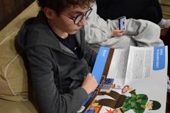 Wychowanek zapoznaje się z treścią plakatu z Polskiej Akcji Humanitarnej.