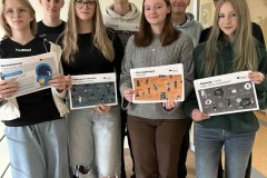 3.	Wychowankowie bursy podczas akcji informacyjnej z okazji „Światowego Dnia Zdrowia Psychicznego” prezentują plakaty i materiały edukacyjne o dbaniu o zdrowie psychiczne.