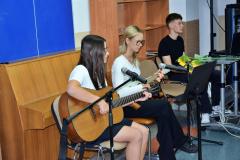 Młodzież gra na instrumentach i śpiewa z okazji Dnia Edukacji Narodowej