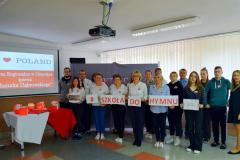 Wychowankowie oraz kadra placówki pozują na tle dekoracji