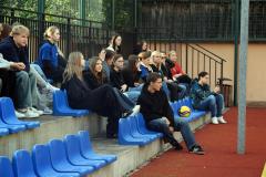 Kibice na meczu siatkówki siedzą na trybunach. Kibicują swoim drużynom.