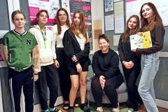 Młodzież prezentuje rozwiązanie zagadki. W tle plakaty z informacjami o „Tygodniu Edukacji Globalnej”