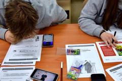 Wychowankowie przeglądają dodatkowe materiały na telefonie i na ich podstawie rozwiązują karty pracy.