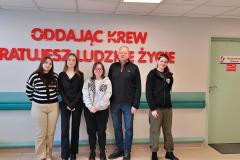 Wychowankowie Bursy wraz z wychowawcą pozują na tle Centrum Krwiodawstwa