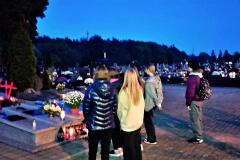 Wychowankowie stoją przy grobie upamiętniającym ofiary komunistycznego terroru