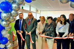 Moment w którym wstęga została przecięta. Przedstawiciele młodzieży oraz goście uśmiechają się trzymając w ręku skrawki wstęgi.