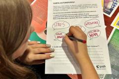 Wychowanka wypełnia tzw. „Kartę autorefleksji”. Na stole leżą materiały edukacyjne.