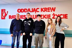 Dumna młodzież z Bursy po oddaniu krwi pozuje do zdjęcia na tle napisu "Oddając krew ratujesz ludzkie życie".