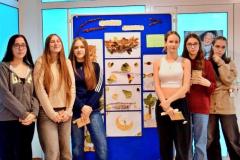 Na zdjęciu widać wychowanków stojących przy wystawie swoich prac wykonanych z jesiennych liści i innych naturalnych materiałów. Wystawa nosi tytuł „Jesienne inspiracje”