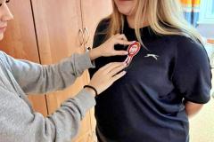 Wychowanka bursy przypina koleżance kotylion patriotyczny. 