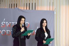 Wychowanki przemawiają do publiczności na tle dekoracji