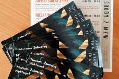 Na stole leżą bilety na seans filmowy do Muzeum Żołnierzy Wyklętych w Ostrołęce oraz ulotka z ofertą filmów na miesiąc marzec.