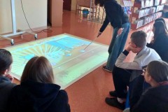 Wychowankowie grają  w gry z wykorzystaniem „Interaktywnej Podłogi  – Pakiet Rozwój Mózgu” w Bibliotece Pedagogicznej.