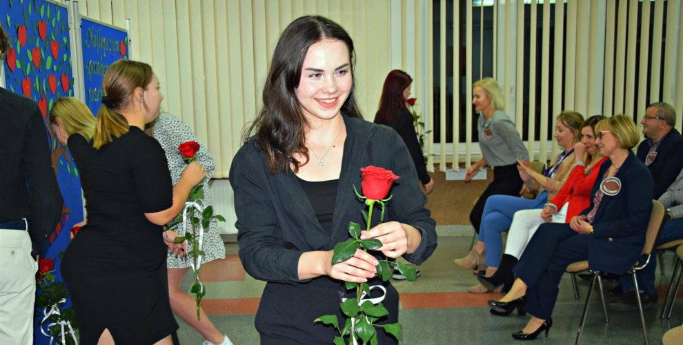 Wychowankowie wręczają czerwone róże pracownikom bursy