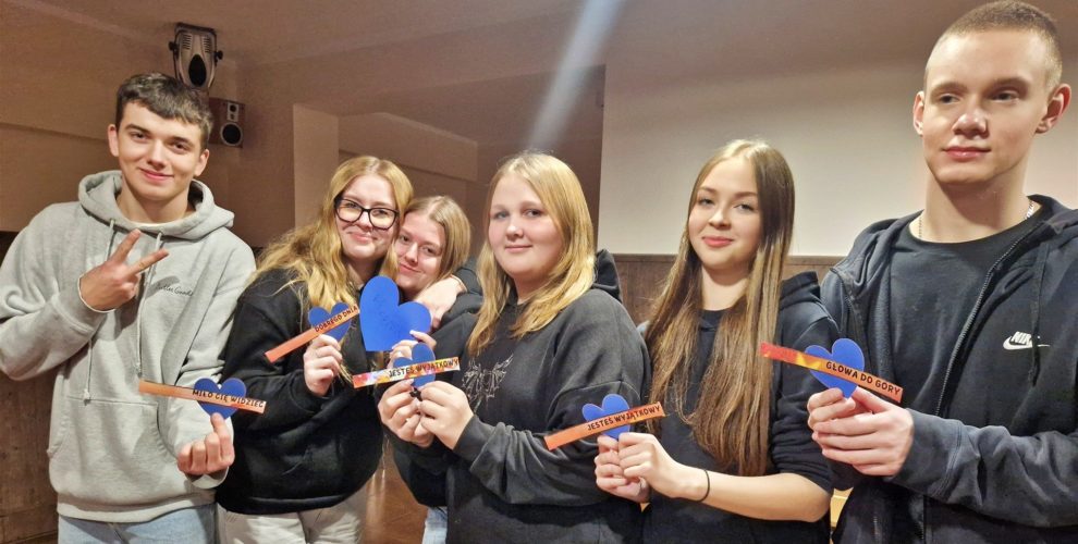 Wychowankowie trzymają serca z "miłym słowem"/wyrażeniem zapisanym na fiszkach