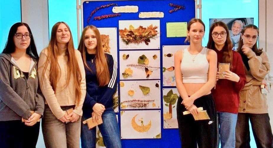 Na zdjęciu widać wychowanków stojących przy wystawie swoich prac wykonanych z jesiennych liści i innych naturalnych materiałów. Wystawa nosi tytuł „Jesienne inspiracje”