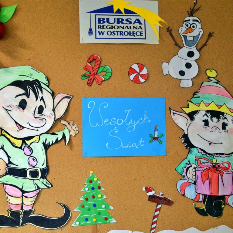 Zdjęcie przedstawia świąteczną gazetkę, na której znajdują się dwa kolorowe elfy wykonane z papieru. Pośrodku umieszczono biały napis „Wesołych Świąt” na niebieskim tle. Całość uzupełniają barwne dekoracje świąteczne wykonane przez młodzież, a w górnej części gazetki widnieje kolorowy logotyp Bursy