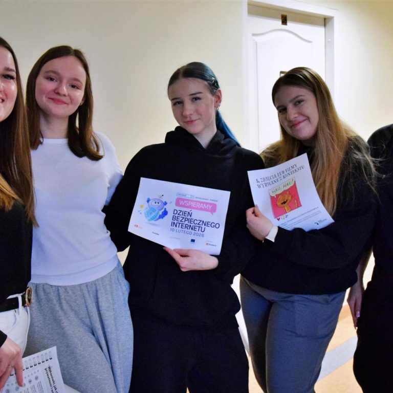 Grupa wychowanek podczas akcji informacyjnej w bursie. Dziewczęta prezentują materiały edukacyjne nt. Dnia Bezpiecznego Internetu