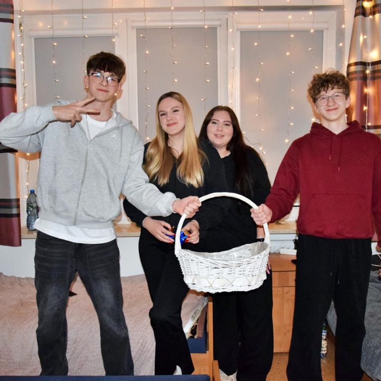 Dwóch chłopców oraz dwie dziewczyny pozują z koszykiem z czekoladkami