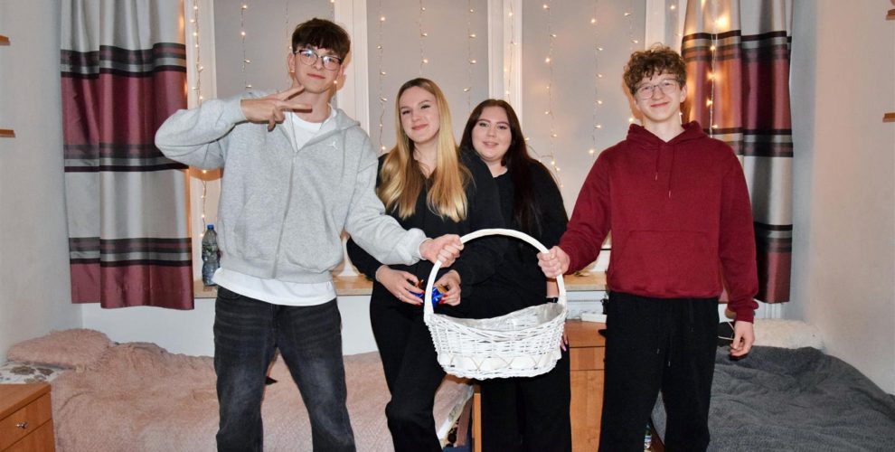 Dwóch chłopców oraz dwie dziewczyny pozują z koszykiem z czekoladkami